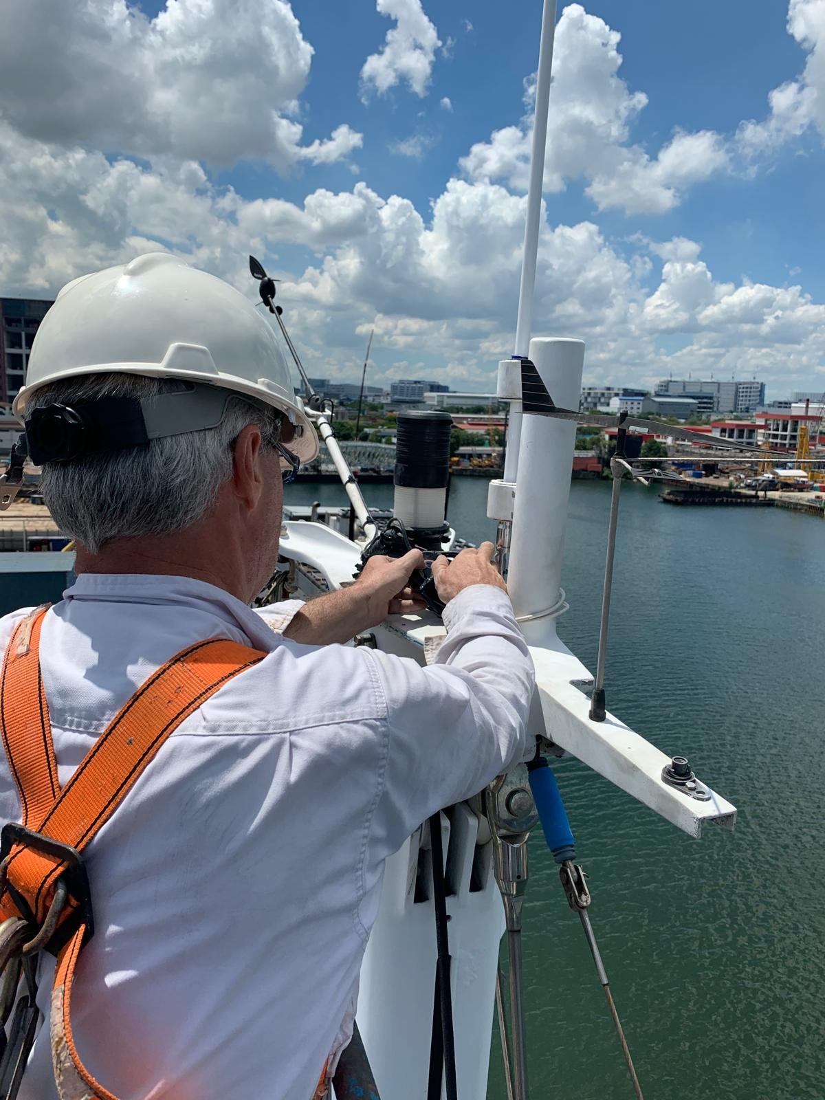 Navyra Group engineer working on vessel equipment at height, Singapore waterway