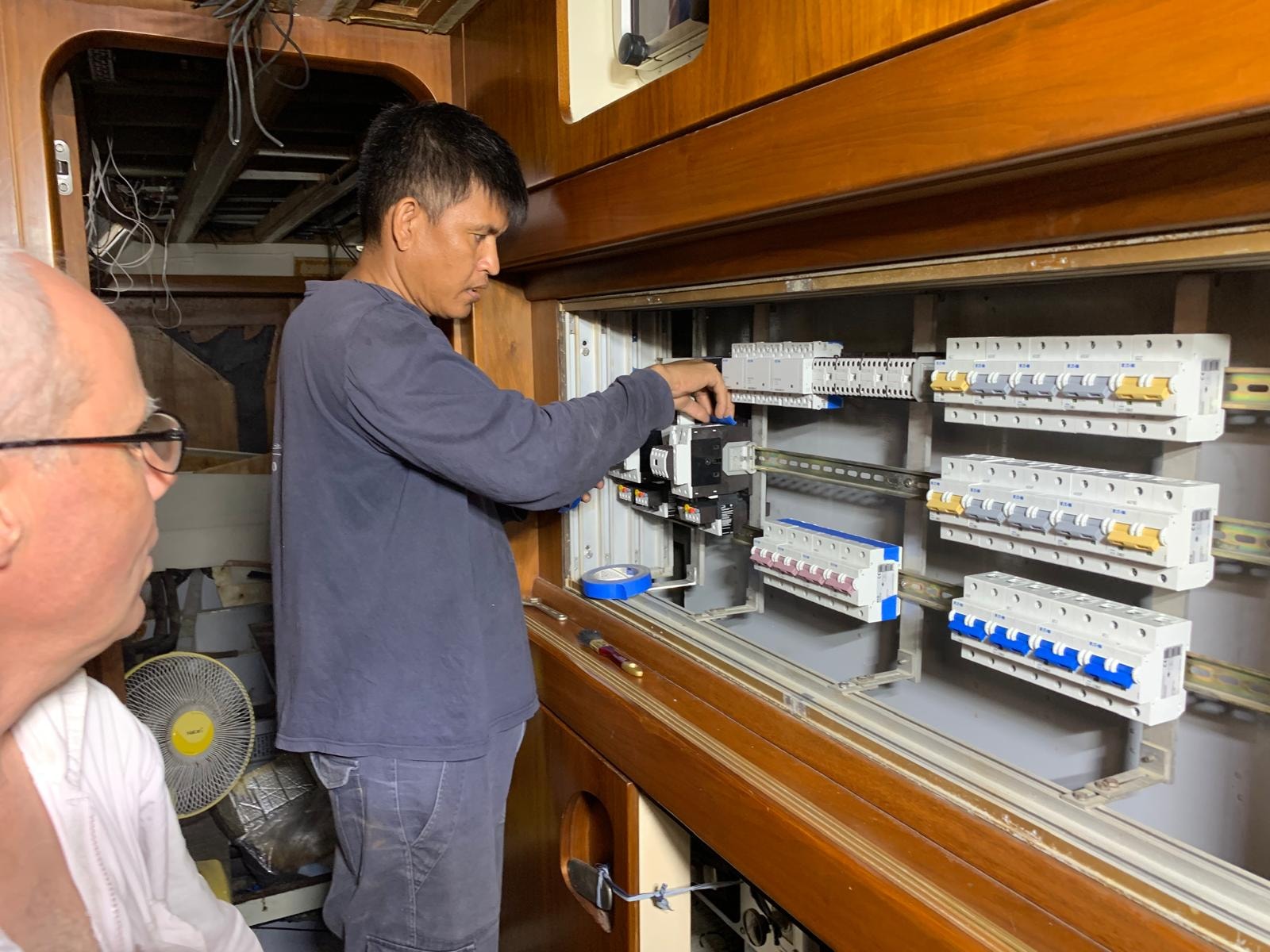 Navyra Group technician working on electrical panel inside vessel