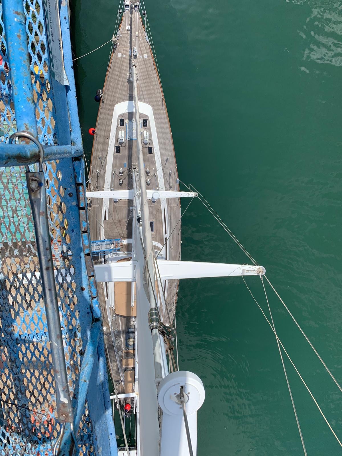Aerial view of sailing yacht alongside scaffolding at Singapore shipyard